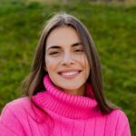 young smiling woman in pink sweater walking in gre 2021 12 09 08 34 19 utc